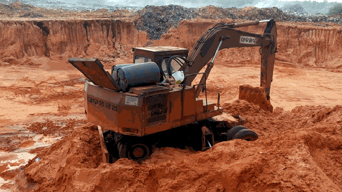 Xe múc cát và hiện trường hố chôn rác khổng lồ - Ảnh: Quế Hà