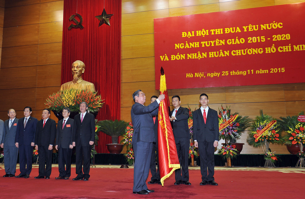 Ông Lê Hồng Anh gắn Huân chương Hồ Chí Minh lên Lá cờ truyền thống ngành Tuyên giáo - Ảnh: TTXVN