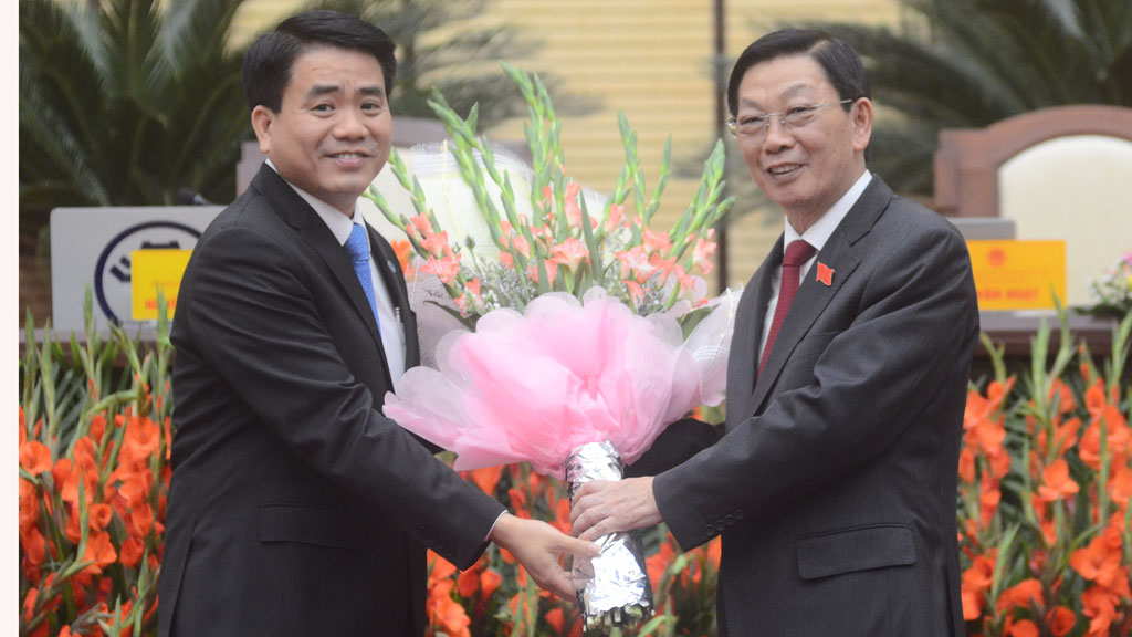 Ông Nguyễn Thế Thảo (phải) tặng hoa cho ông Nguyễn Đức Chung - Ảnh: Ngọc Thắng