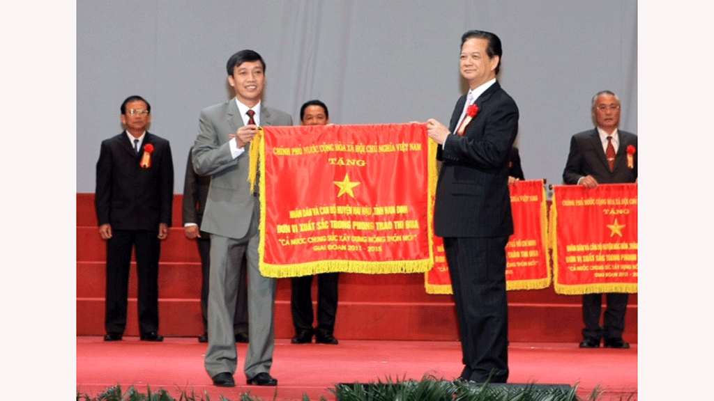 Thủ tướng Nguyễn Tấn Dũng trao cờ thi đua cho các đơn vị - Ảnh: Ngọc Thắng