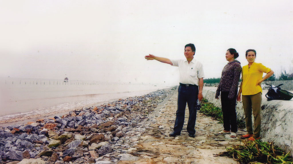 Ông Vũ Trung Kiên với con đê 10 năm xây dựng để bảo vệ Cồn Đen - Ảnh: Trần Hồ 