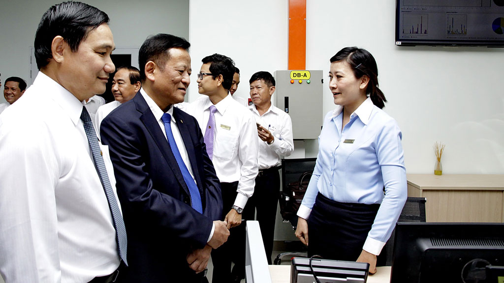 Ông Nguyễn Tấn Lộc (áo vest đen), Phó tổng giám đốc EVN và ông Nguyễn Văn Hợp, Tổng giám đốc EVN SPC (bìa trái), trao đổi với nhân viên Trung tâm CSKH - Ảnh: Đình Hoàng
