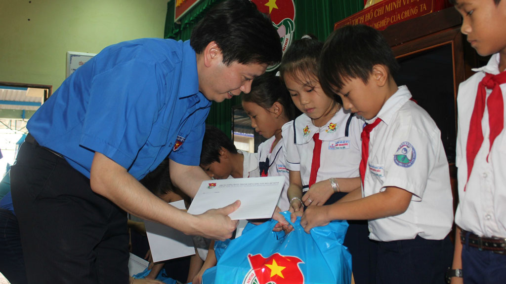 Anh Nguyễn Long Hải trao học bổng cho học sinh  tại Trường tiểu học Tam Quan Bắc, huyện Hoài Nhơn (Bình Định) - Ảnh: Phạm Anh