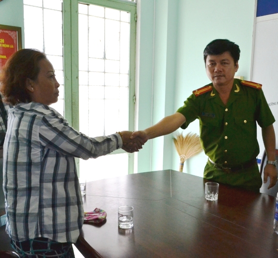 Trung tá Nguyễn Cường (bên phải) thay mặt cấp dưới xin lỗi bà Khả - Ảnh: Nguyễn Tú