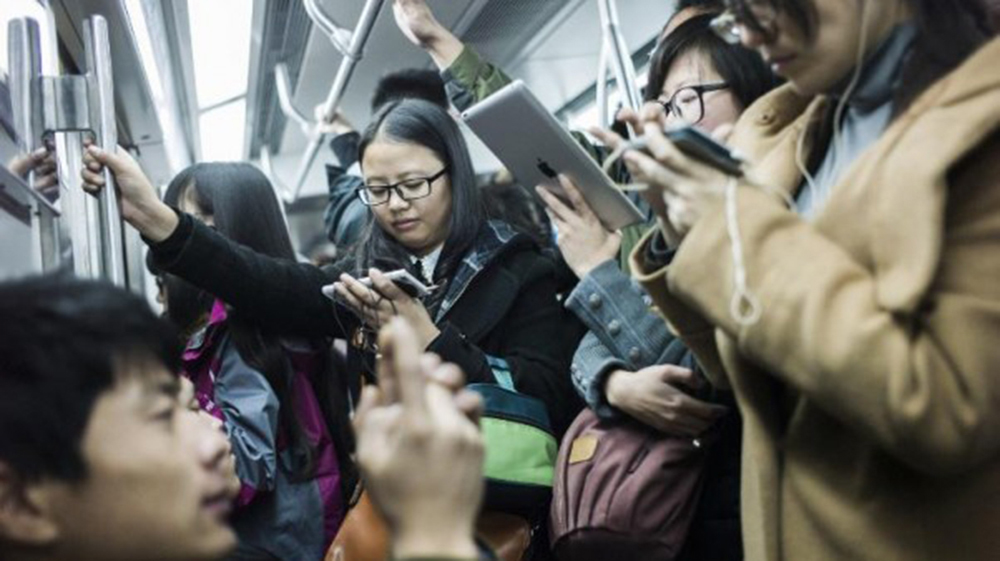 Smartphone được giới trẻ sử dụng mọi lúc, mọi nơi - Ảnh: AFP