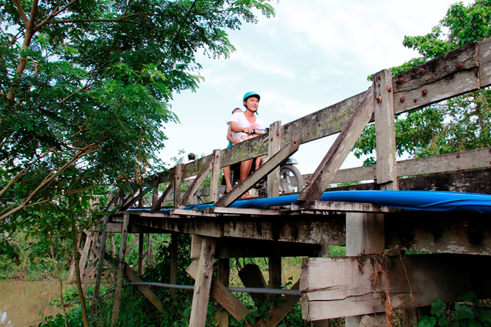 Người dân lưu thông trên cầu gỗ Ba Ngạn tại xã Khánh Hòa - Ảnh: C.T.V