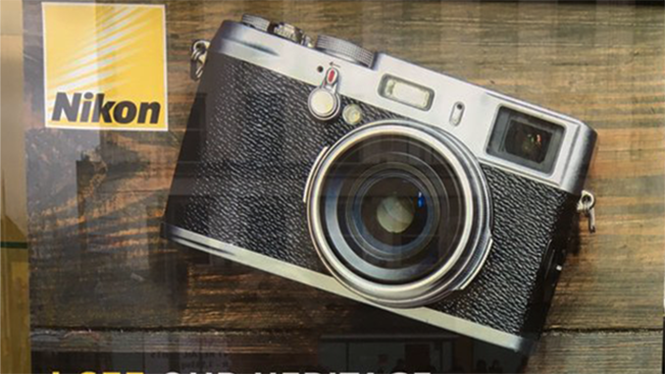 Hình ảnh chiếc máy ảnh Fujifilm X100 được đặt bên cạnh logo Nikon - Ảnh chụp màn hình