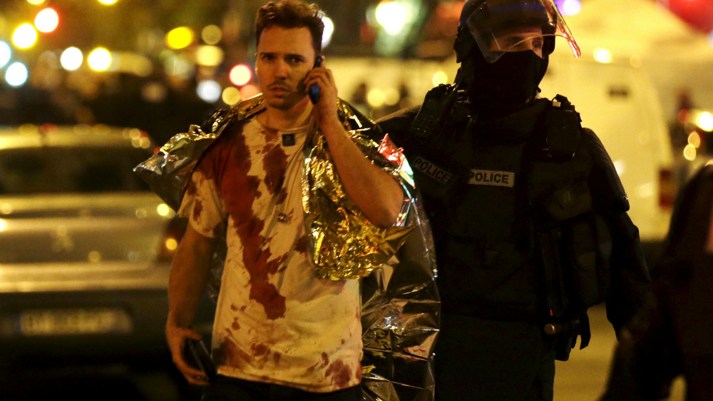 Cảnh sát hộ tống một người sống sót sau vụ tấn công vào nhà hát Bataclan, Paris tối 13.11 - Ảnh: Reuters