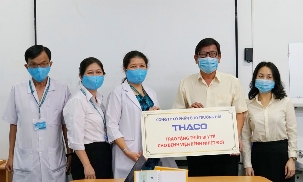 Ông Nguyễn Một - Giám đốc Truyền thông THACO trao tặng thiết bị y tế cho bác sĩ Huỳnh Thị Loan - Phó giám đốc Bệnh viện bệnh Nhiệt đới