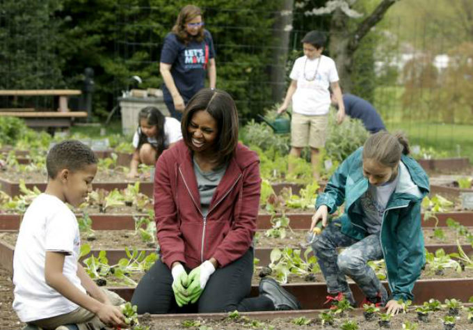 Bà Michelle cùng trẻ em trồng rau - Ảnh: Reuters