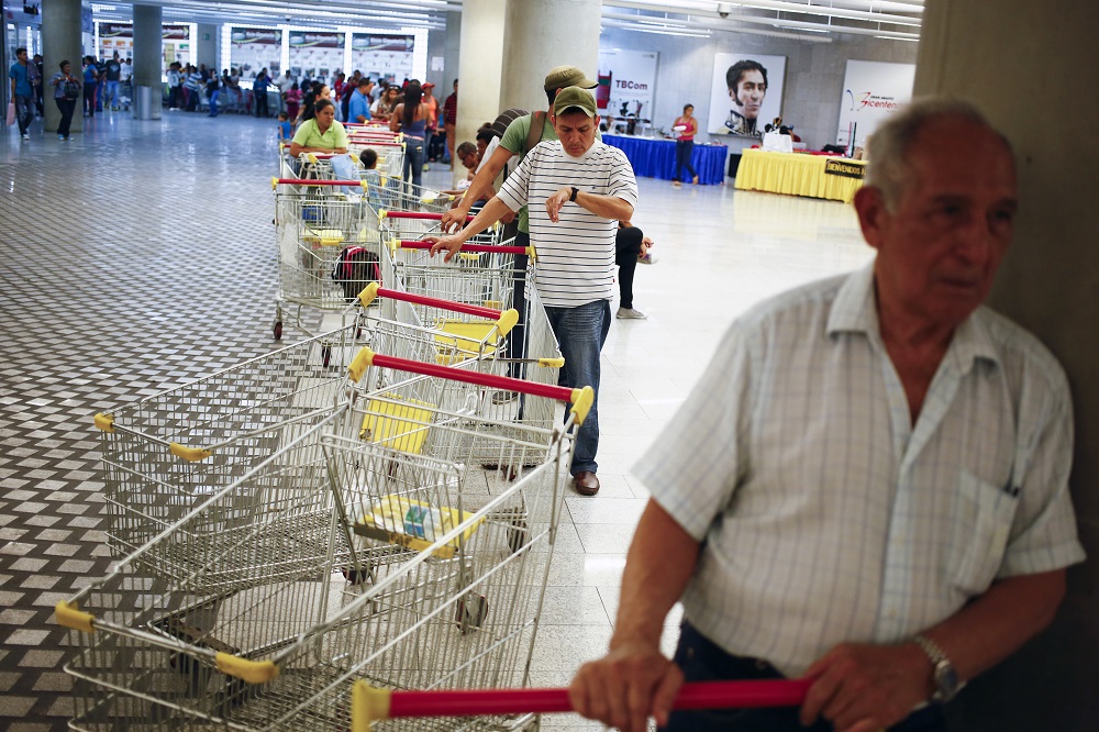 Người dân xếp hàng mua sắm tại siêu thị Bicentenario ở thủ đô Caracas (Venezuela) hồi tháng 5.2014 - Ảnh: Reuters