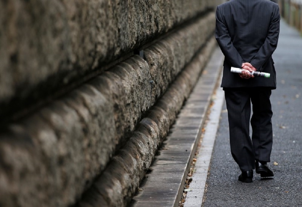 Một người đàn ông đi bộ bên ngoài trụ sở Ngân hàng Trung ương Nhật Bản (BOJ) - Ảnh: Reuters