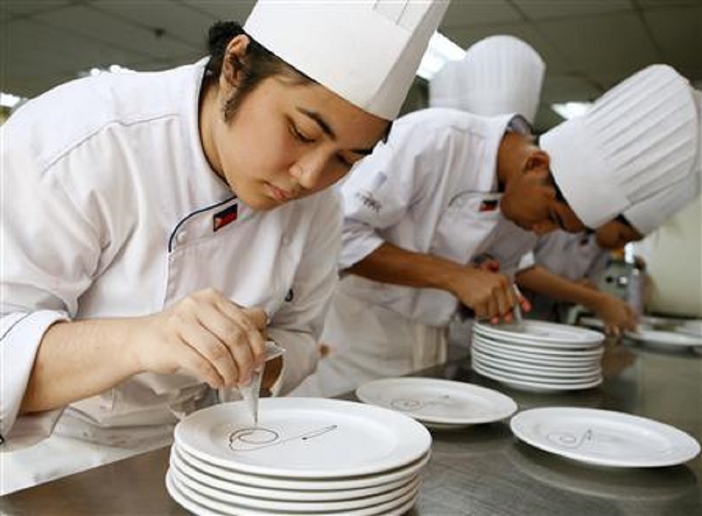 Học viên một trường dạy nấu ăn ở Manila đang chuẩn bị món tráng miệng - Ảnh: Reuters