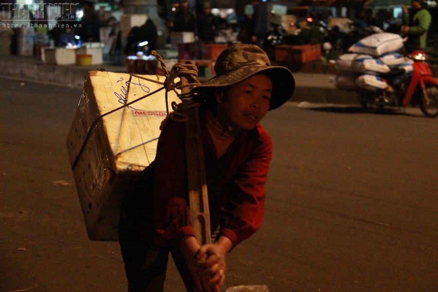 Một phụ nữ oằn lưng cõng hàng tại chợ đầu mối Long Biên lúc 1 giờ 30 phút sáng 5.2