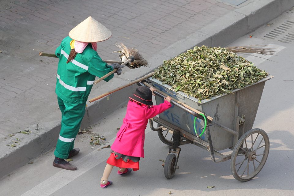 Em bé giúp mẹ đẩy xe rác - Ảnh: Hồ Hải Hoàng