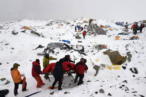 Các nhân viên cứu hộ di chuyển người bị thương trong vụ lở tuyết ở đỉnh Everest - Ảnh: AFP 