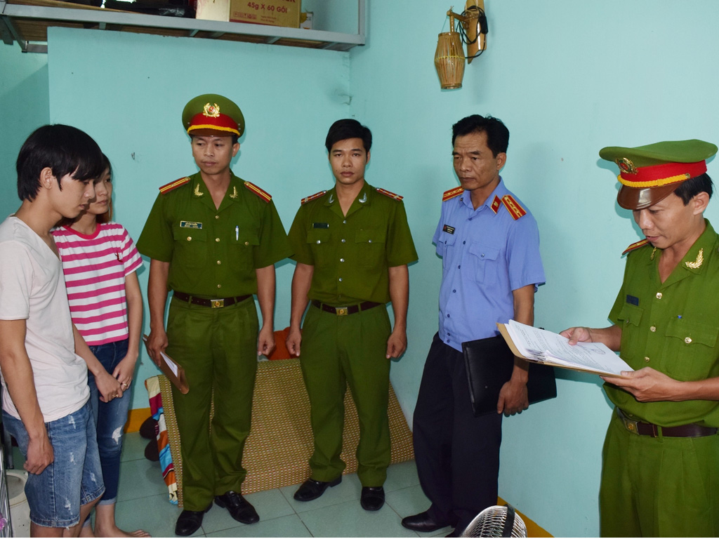 Cơ quan công an đọc lệnh bắt và khám xét nơi ở của Trần Long Hạc và Võ Thị Tuyết Nhi - Ảnh: T.Bình