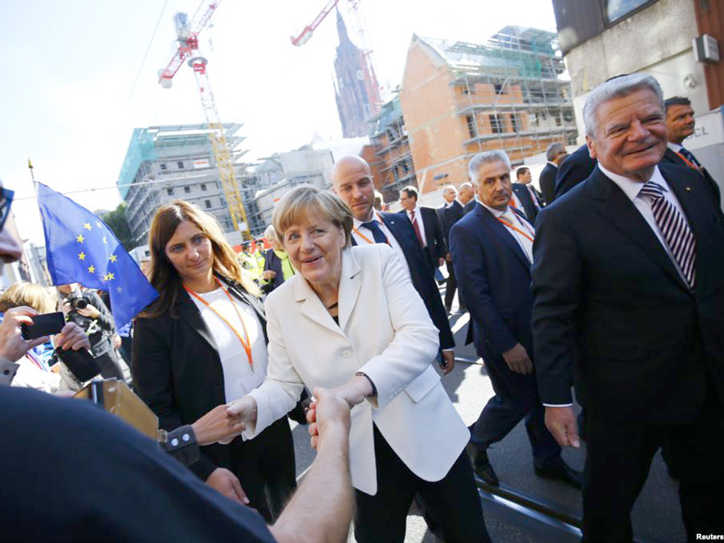Tổng thống Đức Joachim Gauck (phải) và Thủ tướng Angela Merkel (giữa) trên đường phố Frankfurt, Đức ngày 3.10 nhân kỷ niệm 25 năm thống nhất nước Đức - Ảnh: Reuters