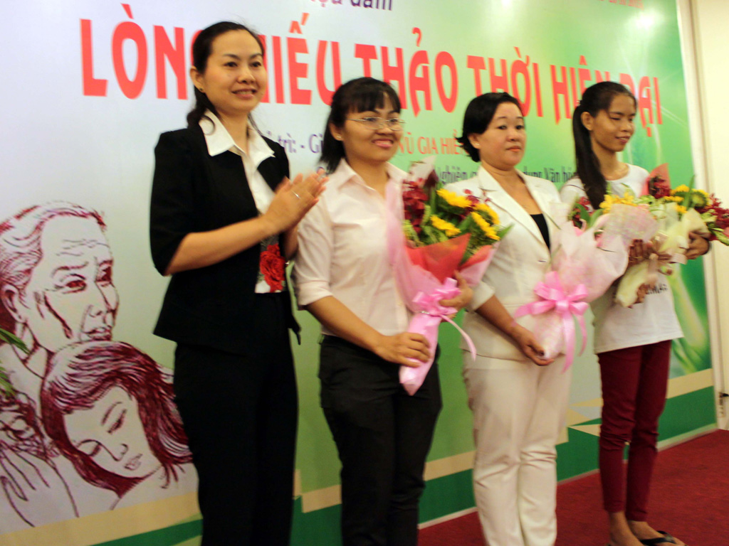 Cán bộ Hội Liên hiệp phụ nữ TP.HCM (bìa trái) tặng hoa cho những tấm gương “Người con hiếu thảo” tại TP.HCM - Ảnh: Như Lịch