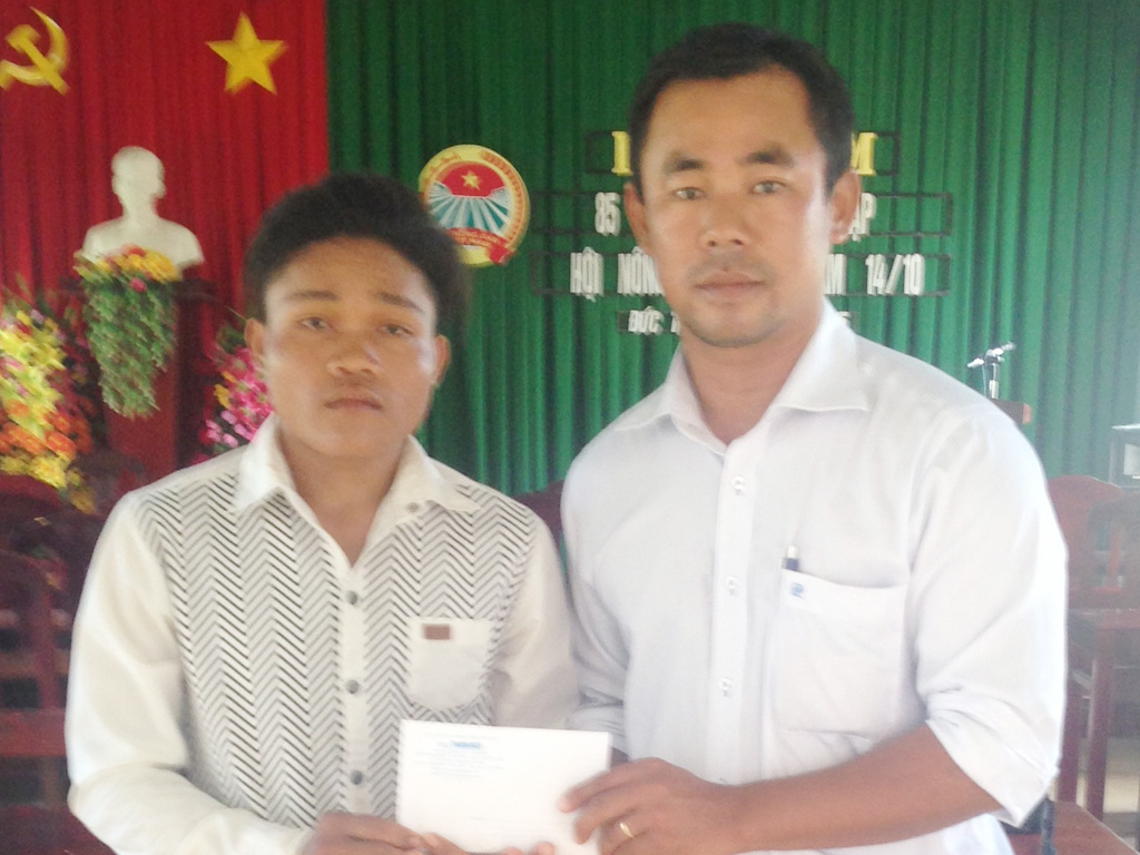 Đại diện Báo Thanh Niên trao tiền bạn đọc giúp em Mang Lỡ - Ảnh: Minh Anh