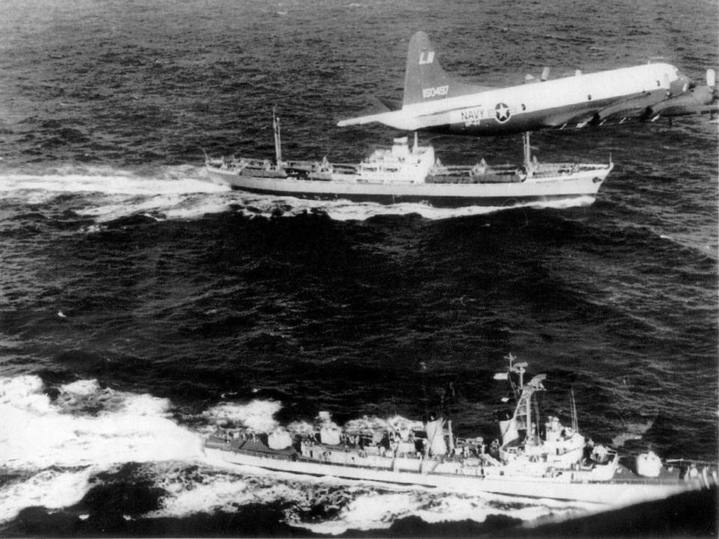 Tàu khu trục Mỹ USS Barry đang kè theo tàu chở hàng Anosov của Liên Xô trong lúc máy bay tuần duyên của Mỹ đảo trên đầu, năm 1962 - Ảnh: The Miami Herald