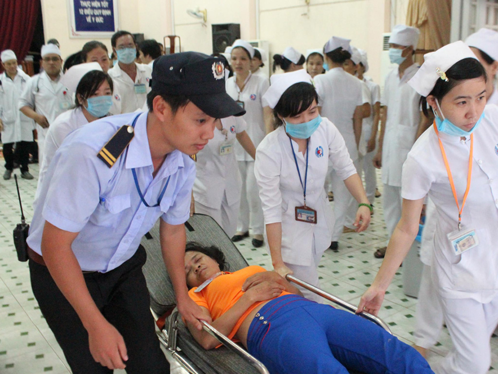 Công nhân cấp cứu tại Bệnh viện đa khoa Bình Dương - Ảnh: Đỗ Trường