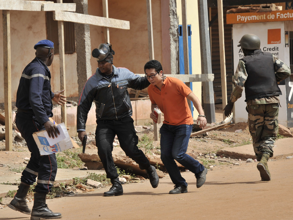 Lực lượng an ninh Mali hộ tống một con tin thoát khỏi khách sạn - Ảnh: AFP