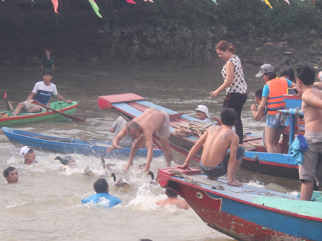 Hàng trăm người vây bắt vịt trên sông trong khuôn khổ hội đua thuyền