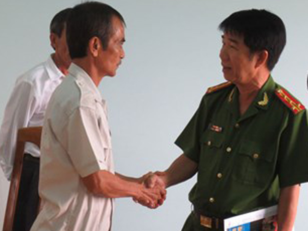 Đại tá Phạm Thật bắt tay và xin lỗi ông Huỳnh Văn Nén sau gần 17 năm ngồi tù oan - Ảnh: Quế Hà