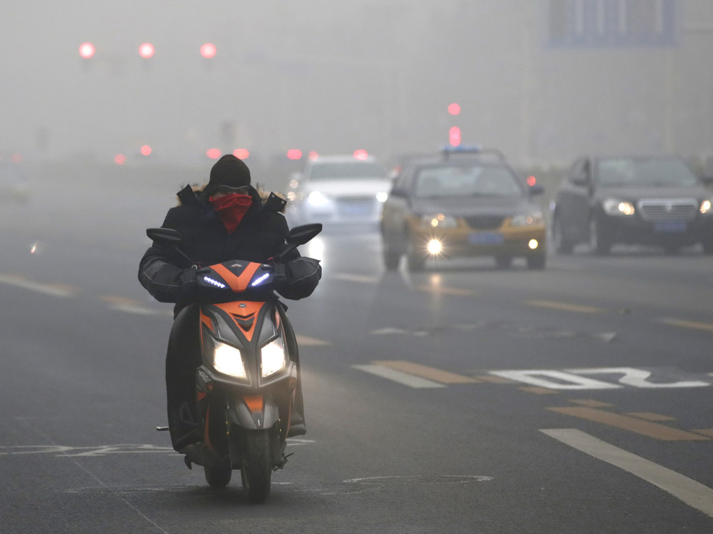 Dân Bắc Kinh di chuyển trong khói mù hồi đầu tháng 12 - Ảnh: Reuters
