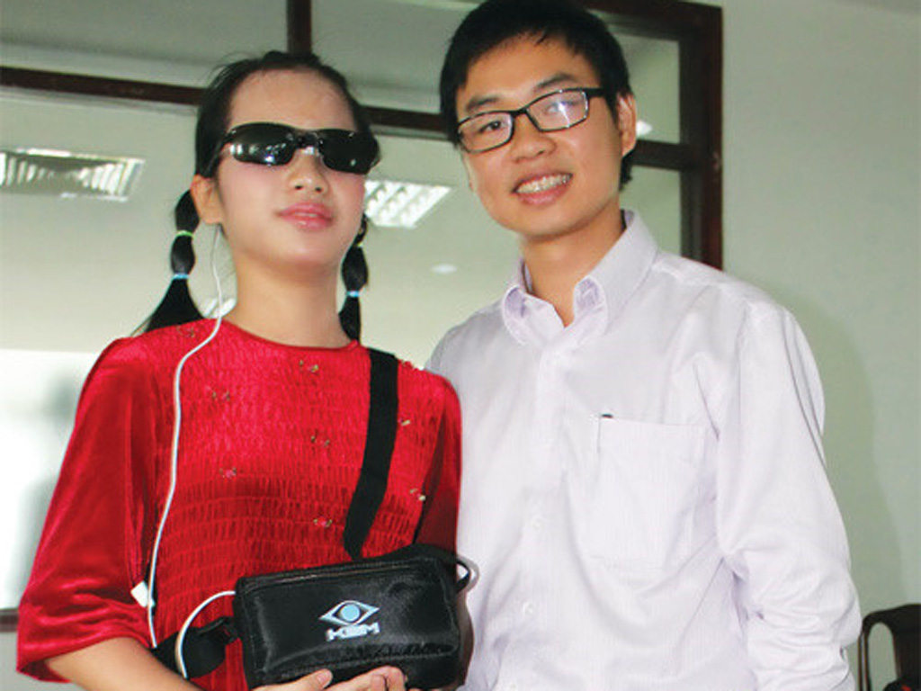 Tiến sĩ Nguyễn Bá Hải, trưởng nhóm nghiên cứu trao tặng “Mắt thần 2” phiên bản năm 2014 cho học sinh khiếm thị - Ảnh: Như Lịch