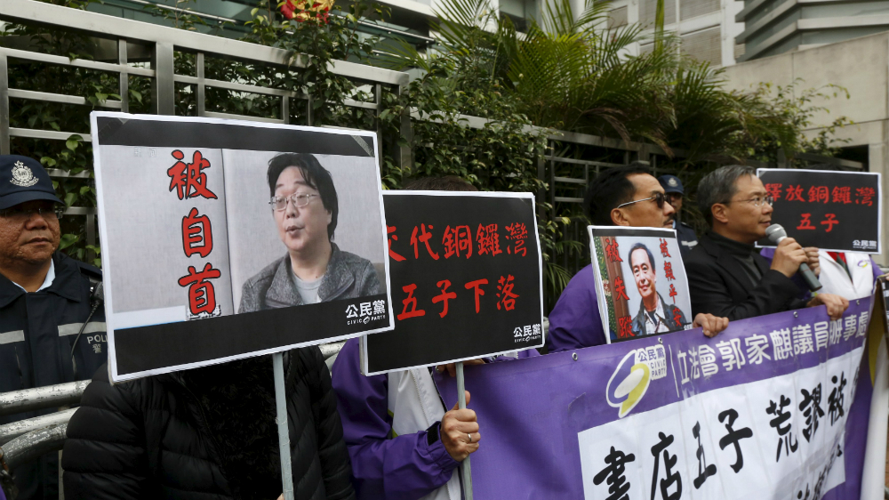 Người biểu tình bên ngoài Văn phòng liên lạc Trung Quốc tại Hồng Kông cầm hình ông Quế Mẫn Hải - Ảnh: Reuters