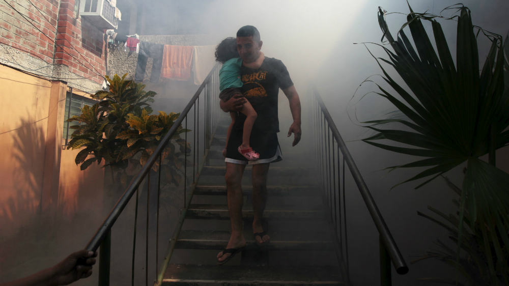 Người dân El Salvador rời khỏi nhà trong lúc khu dân cư đang được khử trùng - Ảnh: Reuters