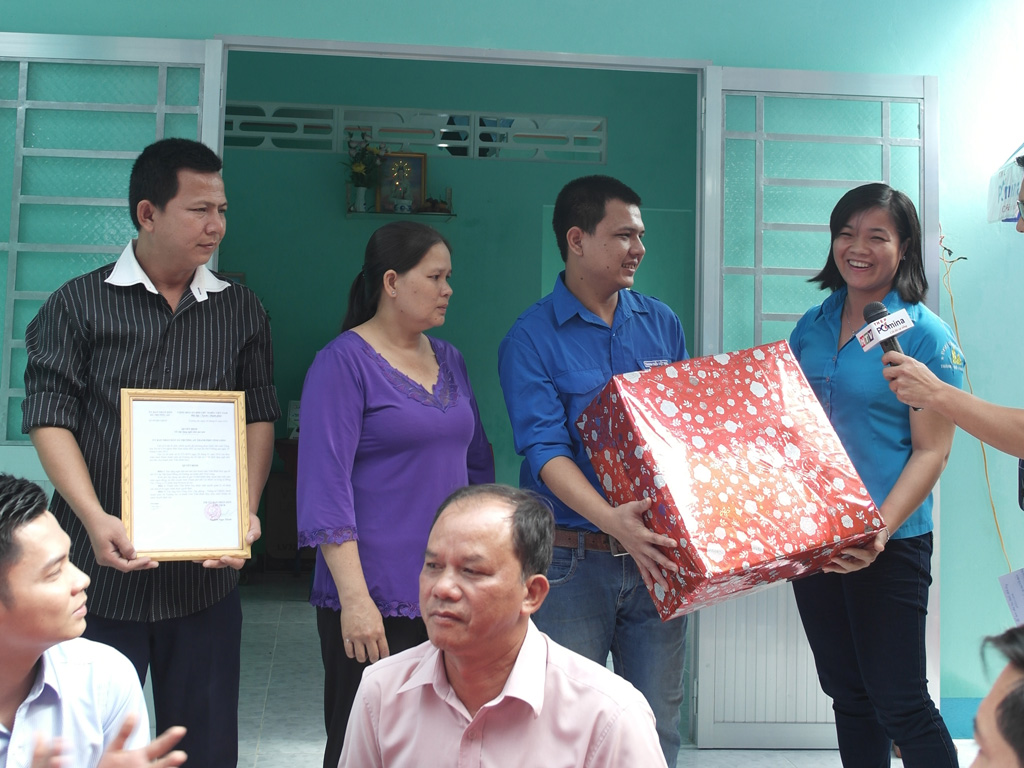 Chị Nguyễn Huỳnh Thu, Bí thư Tỉnh đoàn Vĩnh Long (trái) trao quà cho anh Duy trong ngày được trao tặng căn nhà mới - Ảnh: Thanh Đức