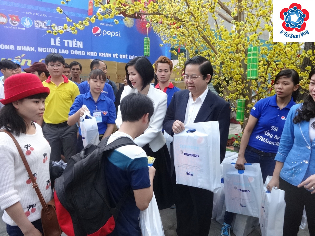 Đại diện Công ty TNHH nước giải khát Suntory PepsiCo Việt Nam trao quà và tiễn các sinh viên lên xe về quê đón tết - Ảnh: Hoàng Việt