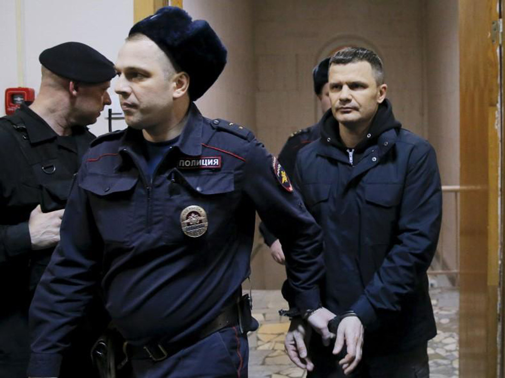 Cảnh sát áp tải ông Dmitry Kamenshchik vào một oà án ở Moscow ngày 19.2 - Ảnh: Reuters