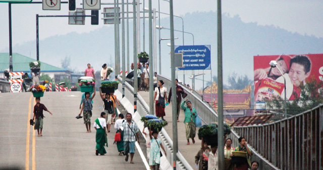 Người dân đi qua cây cầu hữu nghị ở biên giới Thái Lan - Myanmar - Ảnh: AFP