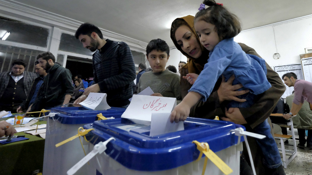 Một phụ nữ tại Tehran mang theo con đi bầu cử - Ảnh: Reuters
