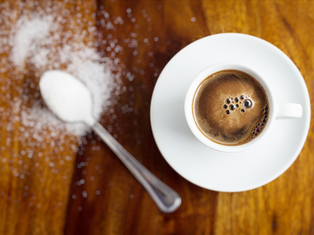 Thêm đường vào cà phê là thói quen ảnh hưởng vòng eo - Ảnh: Shutterstock