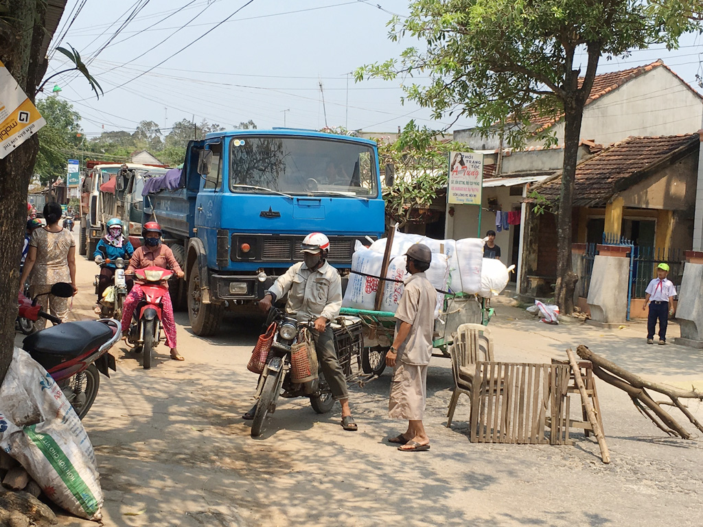 Người dân dựng rào chắn không cho xe tải chở đất, đá lưu thông - Ảnh: Hiển Cừ