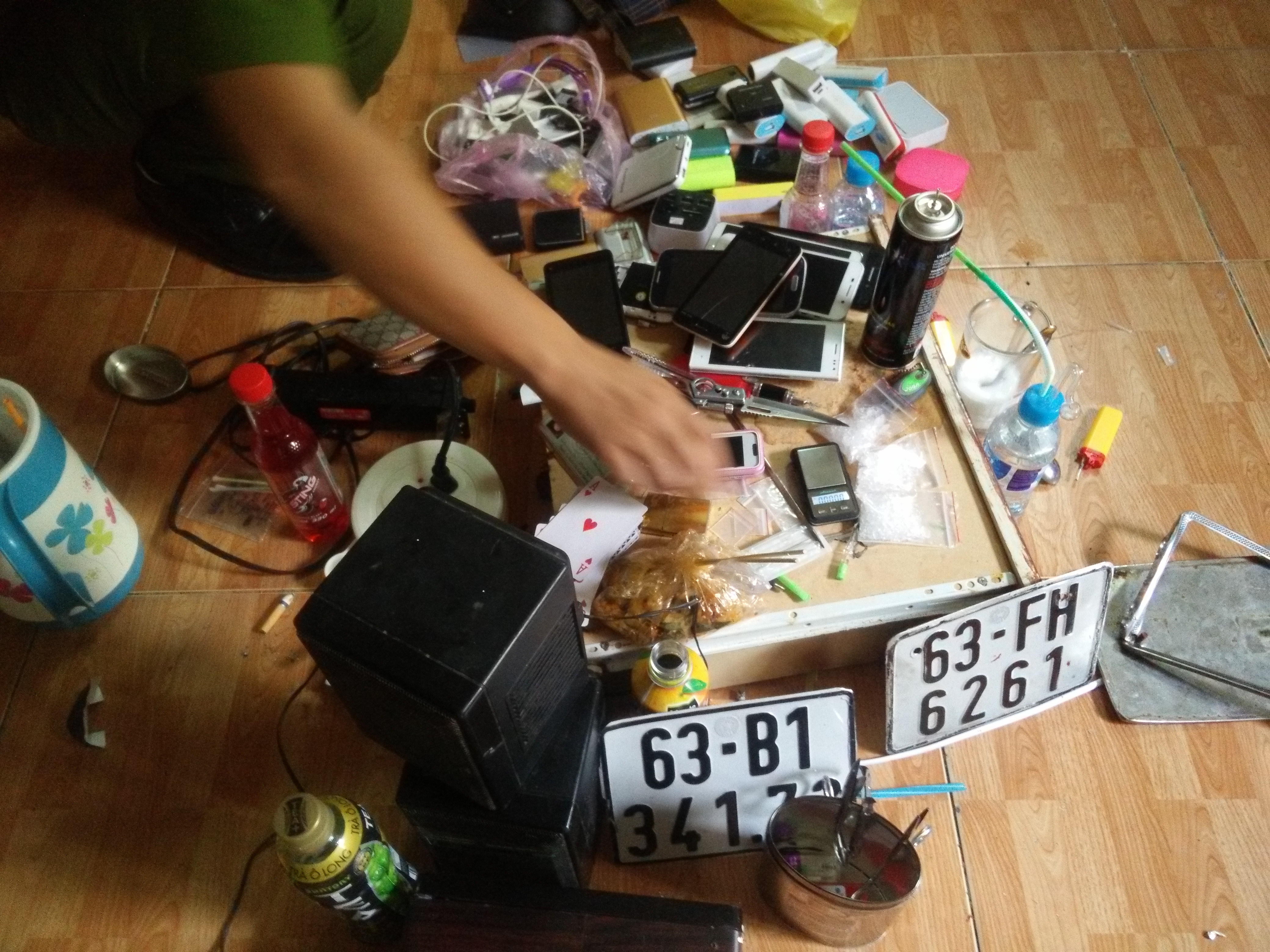 Điện thoại, biển số giả, dụng cụ sử dụng ma túy đá được công an phát hiện trong các phòng ở Khách sạn Tân Kim Sơn - Ảnh: CTV
