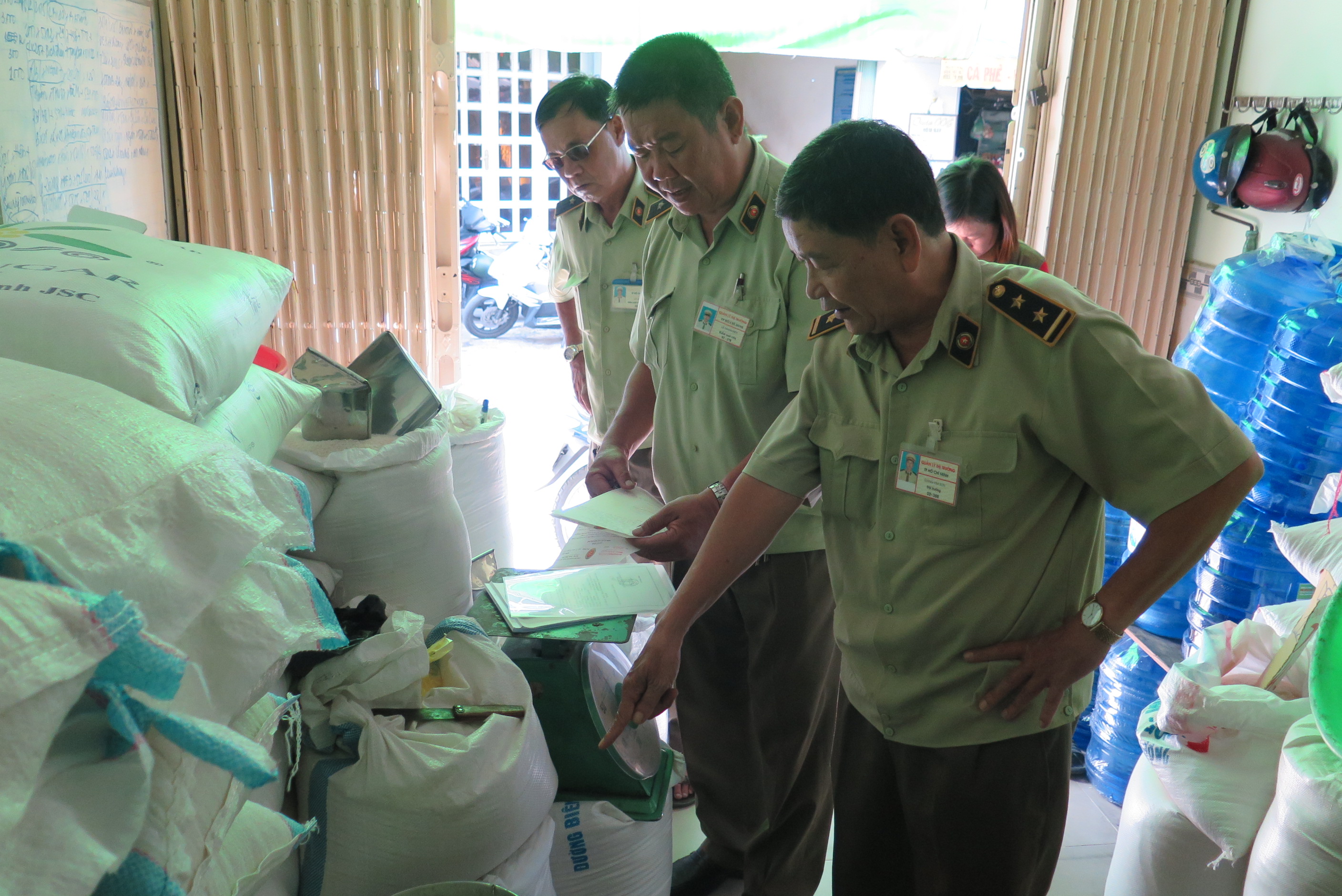 Cán bộ Đội quản lý thị trường quận Phú Nhuận kiểm tra cửa hàng bán gạo nghi có pha nhựa - Ảnh: Trung Hiếu