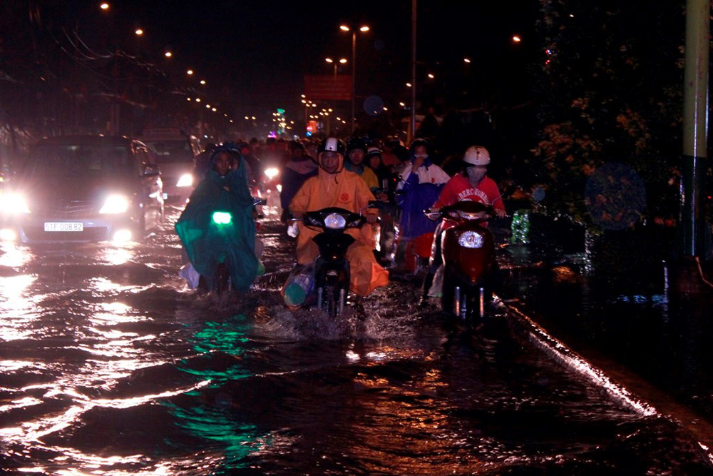 Cảnh tượng người dân TP.HCM lội giữa biển nước sau một cơn mưa lớn - Ảnh: Phạm Hữu