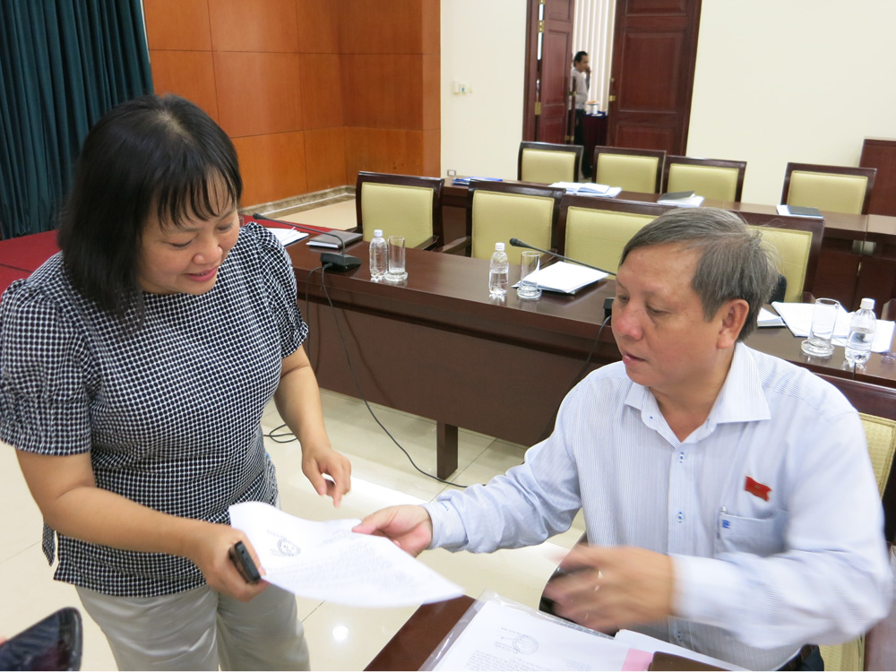 ĐB Trịnh Xuân Thiều cung cấp danh sách các cơ sở kinh doanh "nhạy cảm" thay đổi giấy phép liên tục cho đại diện Sở Kế hoạch và đầu tư - Ảnh: Nguyên Mi