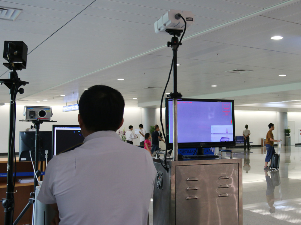 Hành khách được kiểm tra thân nhiệt tại sân bay Tân Sơn Nhất để dự phòng bệnh Zika - Ảnh: Nguyên Mi