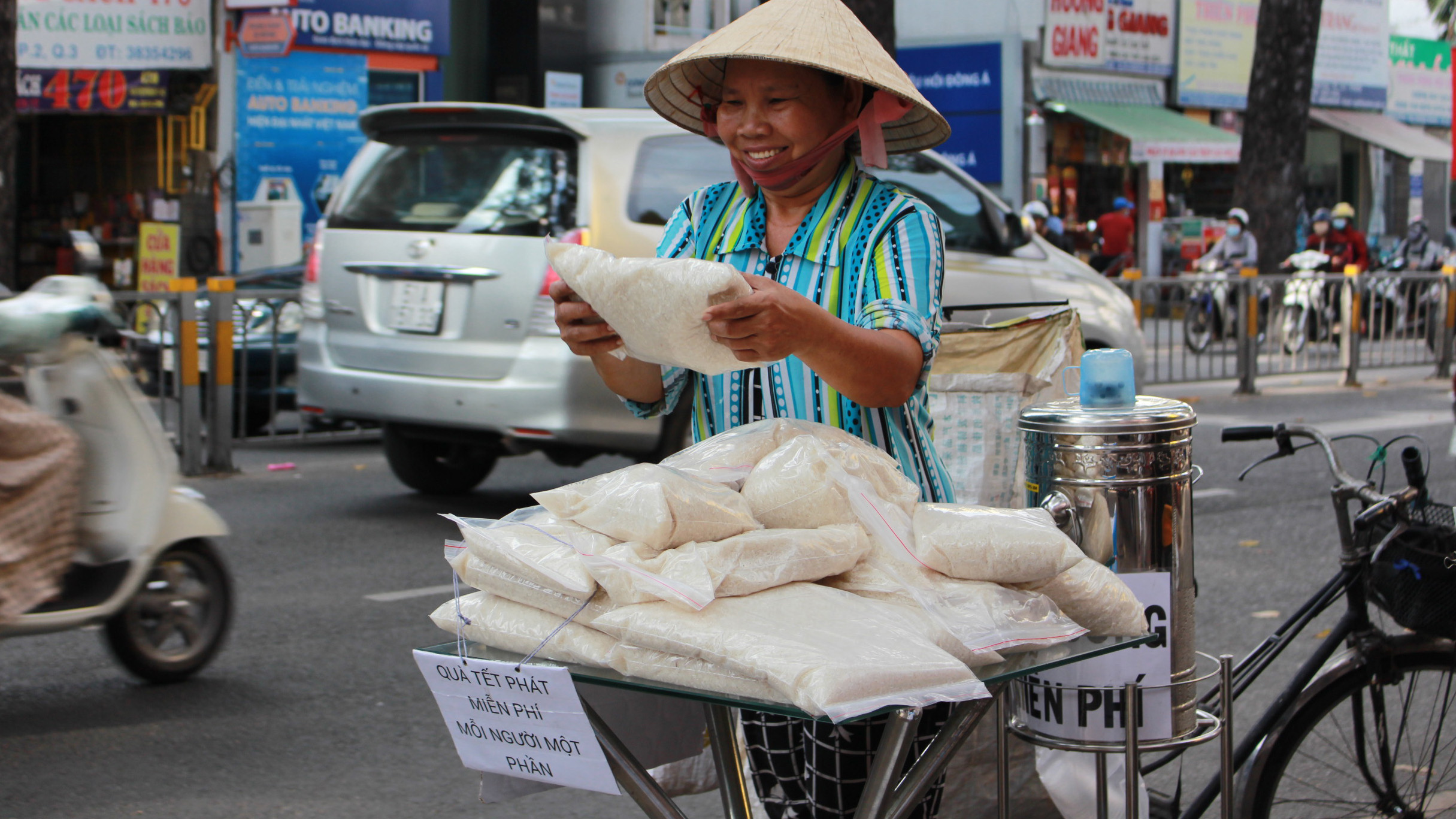 Những người lao động nghèo vui mừng với túi gạo miễn phí - Ảnh: Vũ Phượng