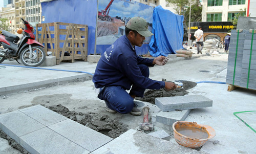 Công nhân cần mẫn lót đá hoa cương trên phố đi bộ - Ảnh: Độc Lập