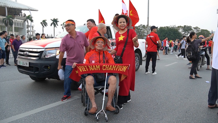 Cổ động viên ngồi xe lăn được vợ ‘hộ tống’ đi cổ vũ đội tuyển Việt Nam
