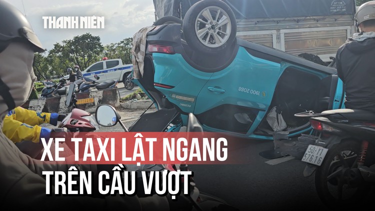 TP.HCM: Lật xe taxi công nghệ trên cầu vượt, tài xế bị thương, giao thông ùn ứ