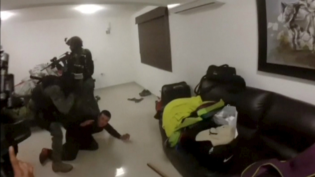 Một người đàn ông bị bắt nằm xuống sàn - Ảnh: Reuters